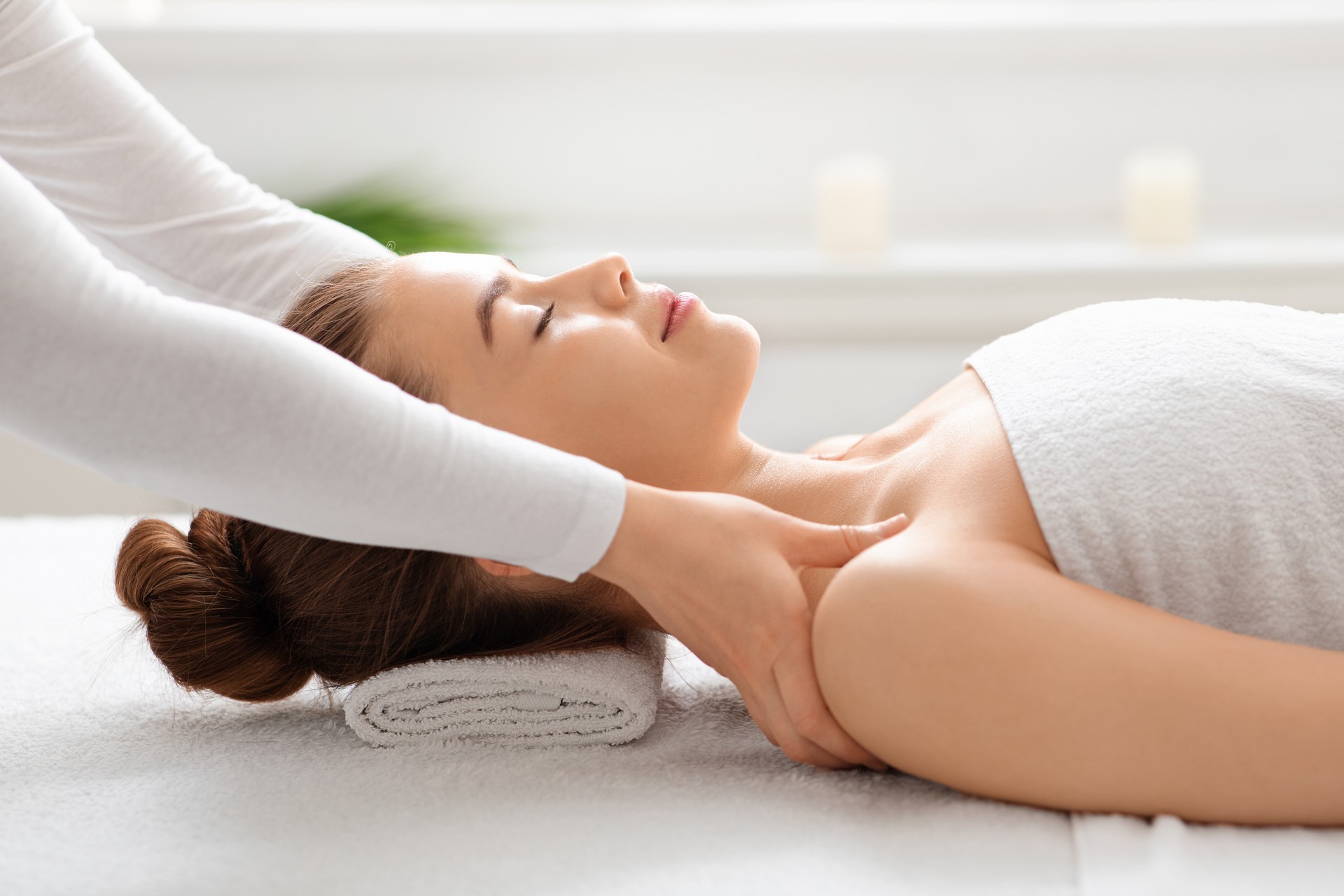 Side view of peaceful young lady having healing body massage